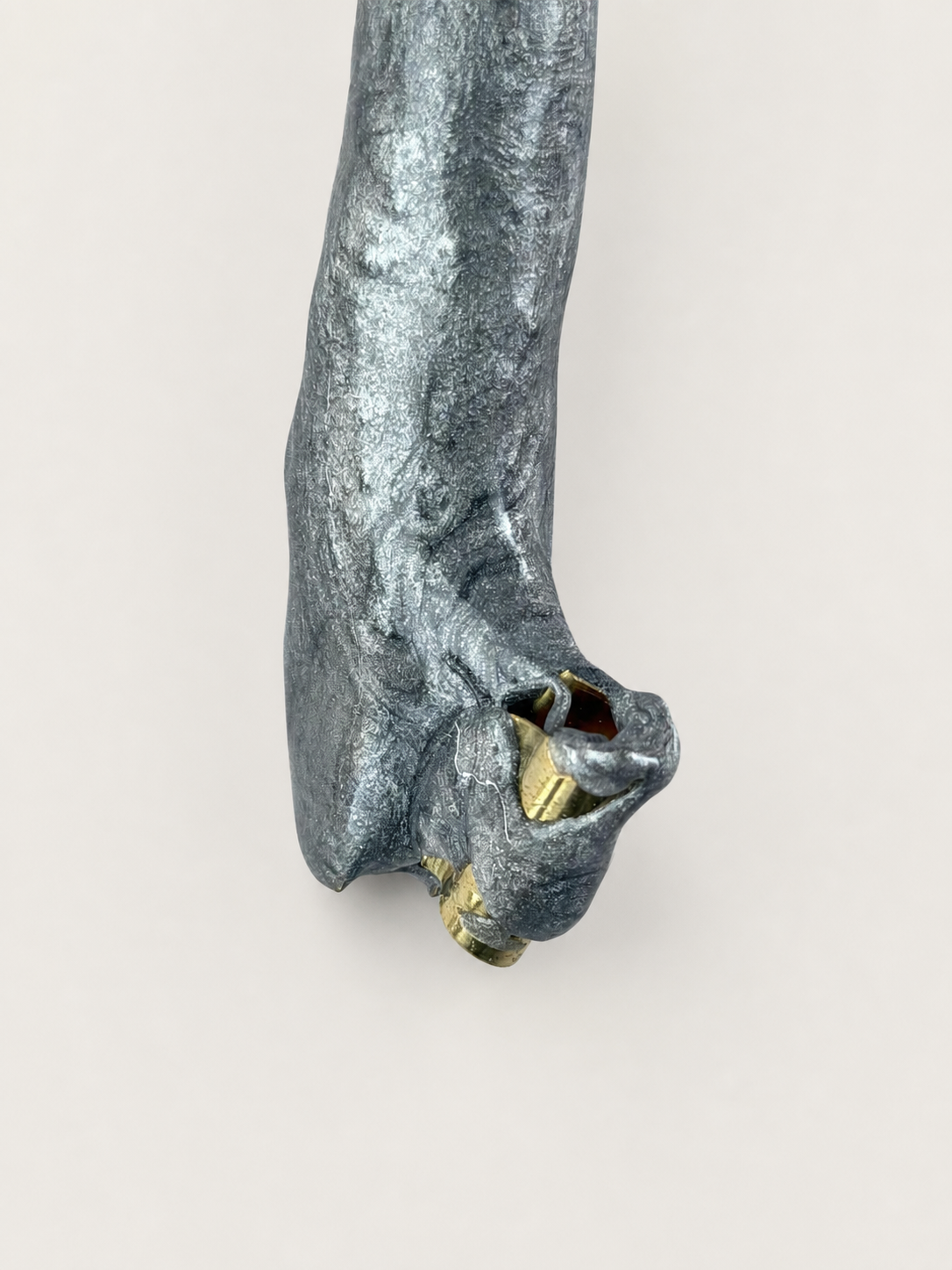 Close detail of the sculpted head and brass parts of an experimental oblique holder
